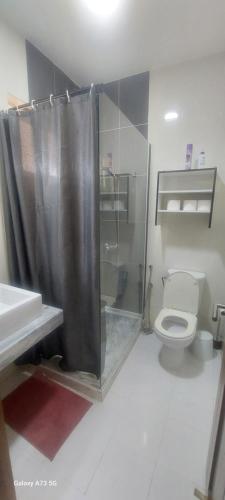 a bathroom with a shower and a toilet and a sink at Oia Mindelo Chambre d'hotes in Mindelo
