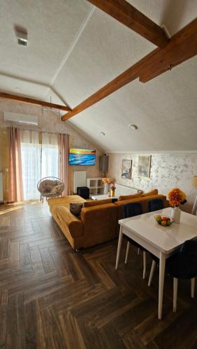 a living room with a couch and a table at Sunrise Riverside House-Private Garden, Jacuzzi & BBQ in Čelarevo