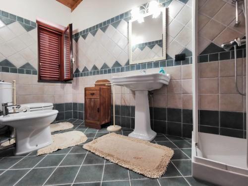 a bathroom with a sink and a toilet and a mirror at Casa La Dimora in SantʼAlfio