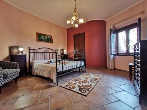 a bedroom with a bed and a chandelier at Casa La Dimora in SantʼAlfio