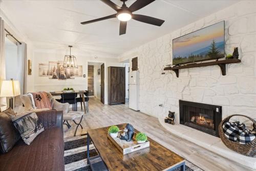 a living room with a stone wall with a fireplace at Baskins Creek II by Beyond Expectations w Balcony in Gatlinburg