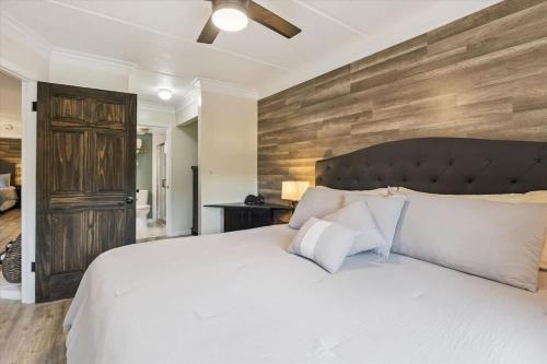 a bedroom with a white bed and a wooden wall at Baskins Creek II by Beyond Expectations w Balcony in Gatlinburg