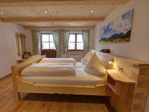 two beds in a room with two windows at Wimmerhof - Chiemgau Karte in Inzell
