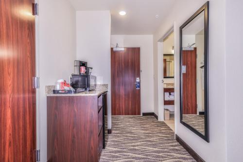 a room with a kitchen with a counter and a mirror at Cobblestone Hotel & Suites - Monte Vista in Monte Vista