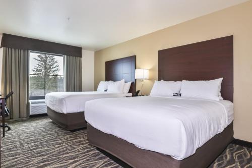 a hotel room with two beds and a window at Cobblestone Hotel & Suites - Monte Vista in Monte Vista