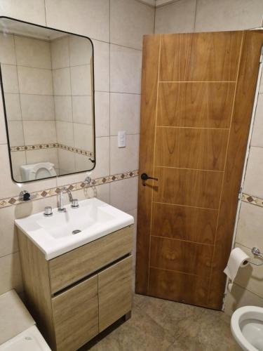 a bathroom with a sink and a wooden door at Lugar de Descanso Azul in Azul