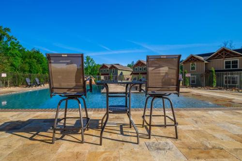 two chairs and a table in front of a pool at Bears Haven – Elegant 3 BR Chalet Game Area, Hot Tub, see through fire place in Gatlinburg
