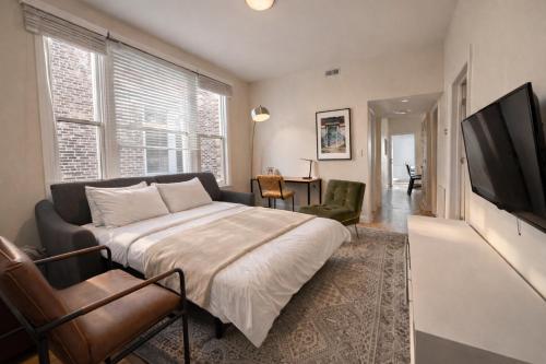 a bedroom with a bed and a flat screen tv at Flexhome Wicker Park - Stylish 2BR - Sleeps 6 in Chicago