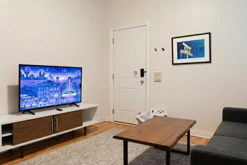 a living room with a flat screen tv on a cabinet at Flexhome Wicker Park - Stylish 2BR - Sleeps 6 in Chicago