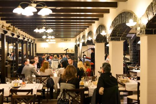 a group of people sitting at tables in a restaurant at Hotel Gradina Morii in Sighetu Marmaţiei