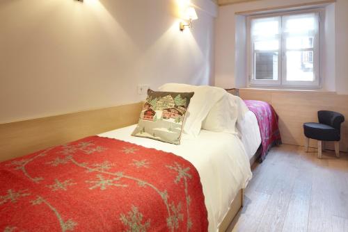 um quarto com uma cama com um cobertor vermelho e uma janela em Val de Ruda Luxe 38 by FeelFree Rentals em Baqueira-Beret