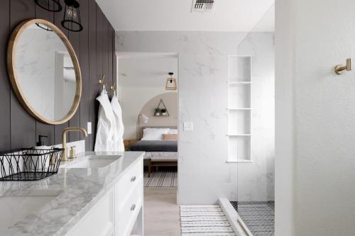 a bathroom with a sink and a mirror and a bed at Copper Cactus House Pool, Spa, Golf! in Queen Creek