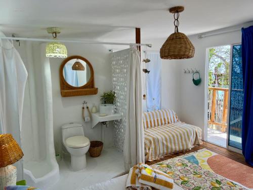 a bathroom with a toilet and a sink and a mirror at Mio Mio Beach in Barú