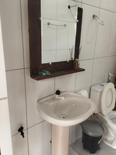 a bathroom with a sink and a toilet and a mirror at COMPARTILHADO Do TERRÃO in Três Marias