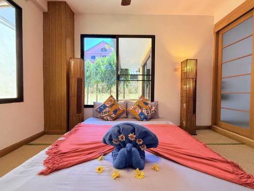 a bedroom with a large bed with flowers on it at Yellow House Garden Pool Villa in Chiang Mai