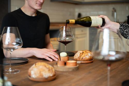 a person pouring a glass of wine on a table at Suite Het Koetshuis in Bennekom