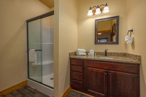 a bathroom with a shower and a sink and a mirror at Poolside Paradise - Luxe 4BR Chalet with Indoor Pool, Theater and Game Room in Gatlinburg