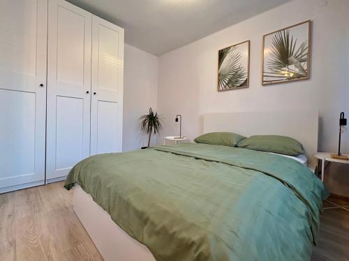 a bedroom with a large green bed in it at Przy Zamenhofa in Nowa Sól