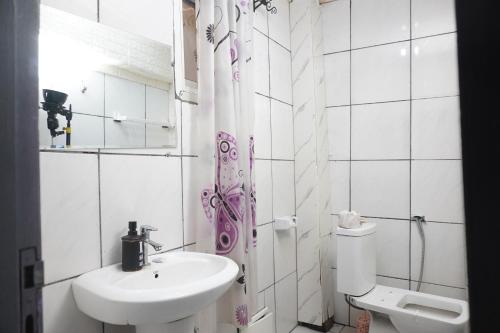 a white bathroom with a sink and a toilet at Complexe A8CLOS in Douala