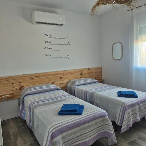 two beds in a room with a white wall at Casa Rural Mayné in Villafranca de los Caballeros