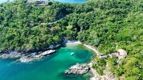 an aerial view of a cove with a house and a beach at Tuya Casita in Zihuatanejo