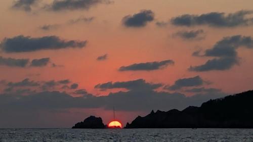 a sunset over the ocean with the sun in the sky at Tuya Casita in Zihuatanejo