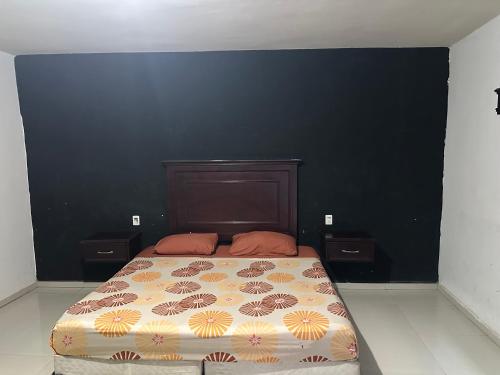 a bedroom with a bed and a black wall at Motel Love in Altamira