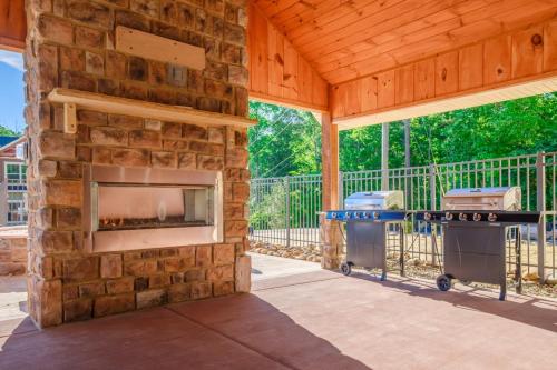 a stone fireplace in a screened in porch with a grill at Luxury Chalet w Indoor Pool, Theater Room & Game Loft — 4 Miles to Gatlinburg in Gatlinburg