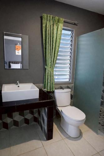 a bathroom with a toilet and a sink and a window at Na Ville Resort in Ban Huai Yai
