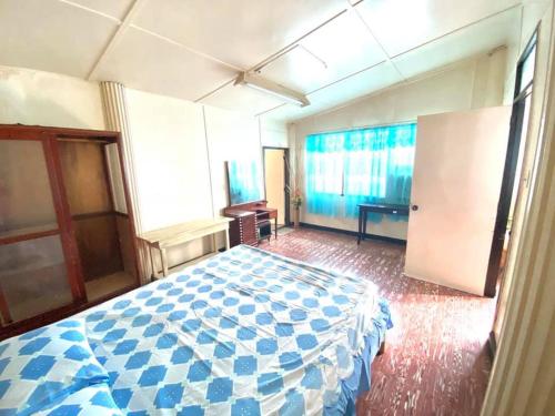 a bedroom with a blue and white bed in a room at Tamari's Rest House in Lian