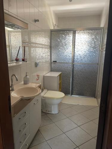 a bathroom with a toilet and a sink and a shower at Lareconexao in Foz do Iguaçu