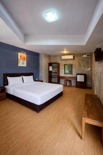 a bedroom with a large white bed and a table at Na Ville Resort in Ban Huai Yai