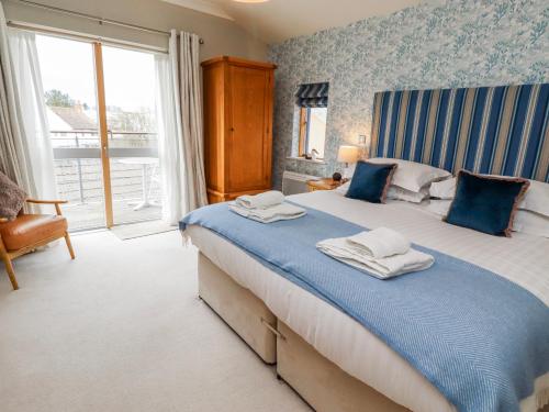 a bedroom with a large bed with towels on it at Cuddy's Holm in Seahouses