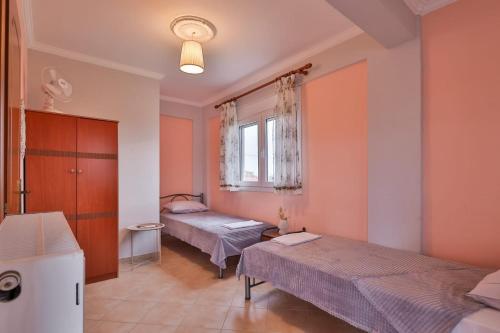 a bedroom with two beds and a window at Villa Lydia Kariani in Karianí