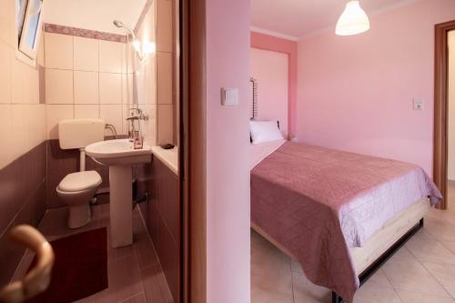 a bedroom with a bed and a sink and a toilet at Villa Lydia Kariani in Karianí
