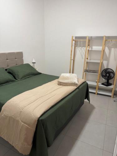 a bedroom with a green bed and a ladder at Casa da Glória 1 in Diamantina