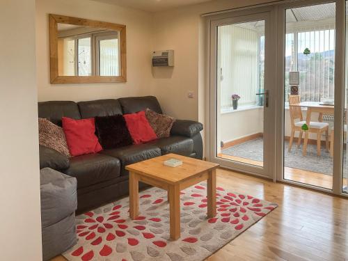 a living room with a couch and a table at Thistle Dubh in Drumnadrochit