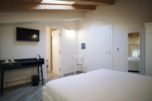 a bedroom with a bed and a desk and a television at Casa Marinari in Scalea