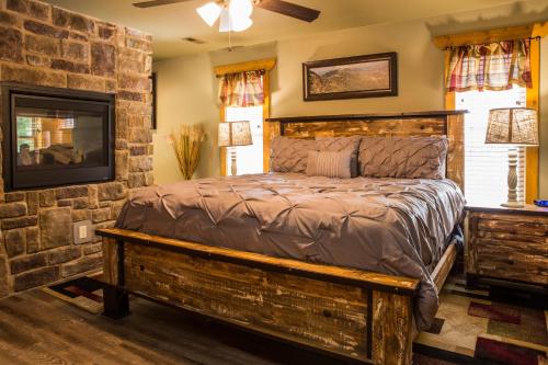 a bedroom with a bed in a stone wall at Gatlinburg Pool Pad – Luxury 4BR Chalet, Indoor Pool, Sauna & Theater Room in Gatlinburg
