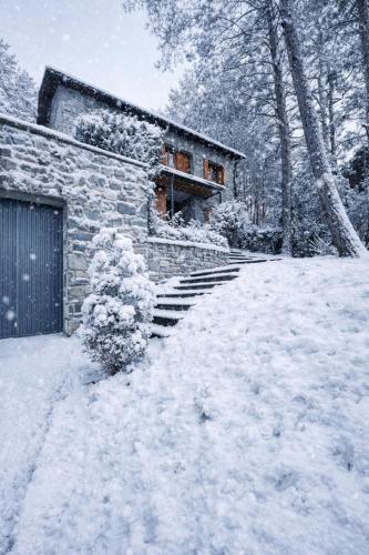 a house covered in snow in front of a building at Villa Zocotin in Villanúa