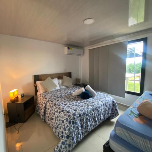 a bedroom with a bed and a window at Finca Campestre en el Lago Calima "Doña Ime" in Calimita