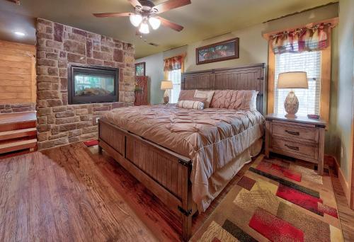 a bedroom with a large bed and a stone wall at Break Time - Modern 5BR with hot tub, game room, air hockey and resort pool in Gatlinburg