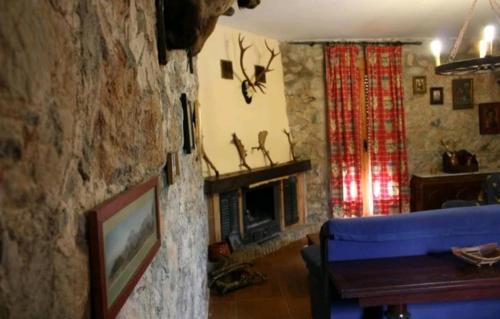 a living room with a blue couch and a stone wall at Complejo Turístico Fuenmayor in Torres
