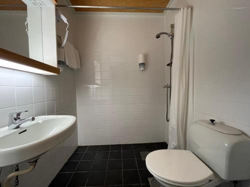 ein Badezimmer mit weißer Toilette und Waschbecken in der Unterkunft Hotel Videseter in Stryn