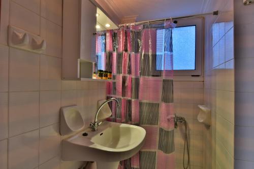 a bathroom with a sink and a shower curtain at Morpheas Rooms in Palaiochora