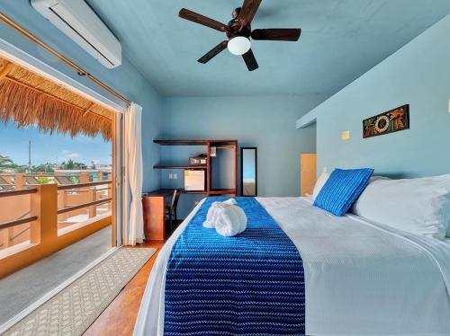 a bedroom with a bed with a ceiling fan and a balcony at Casa Bella Noche Isla Mujeres in Isla Mujeres