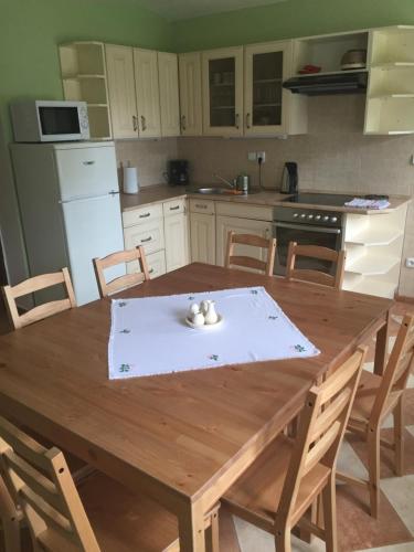 a kitchen with a wooden table with chairs and a table and a kitchen with at Rekreační dům u Marušky in Božanov