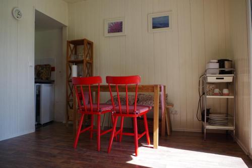 a kitchen with two red chairs and a table at Haus Silke am See in Groß Köris