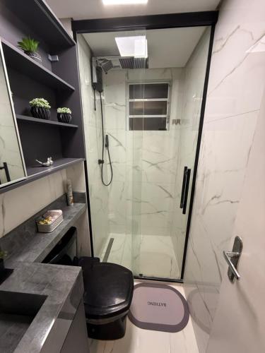 a bathroom with a shower with a glass door at Carvalho Home in Londrina