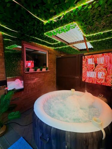 a large jacuzzi tub in a room with neon signs at Hot Tube&Private Driveway&11 Guests Family&Contractors Bedford in Bedford